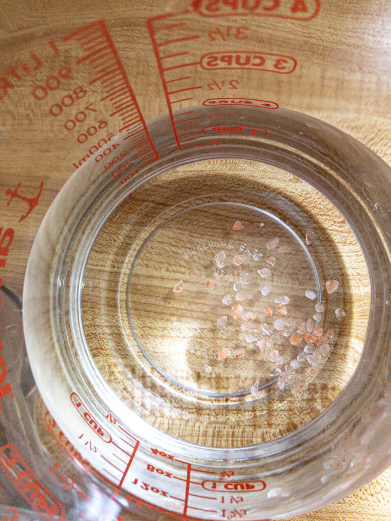 measuring cup of water with himalayan salt
